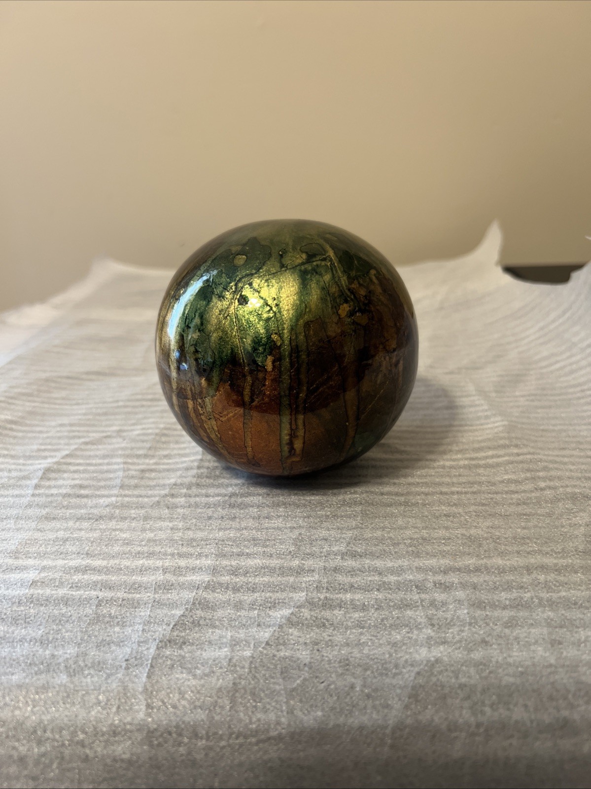 ceramic gazing ball paperweight with a colorful finish.