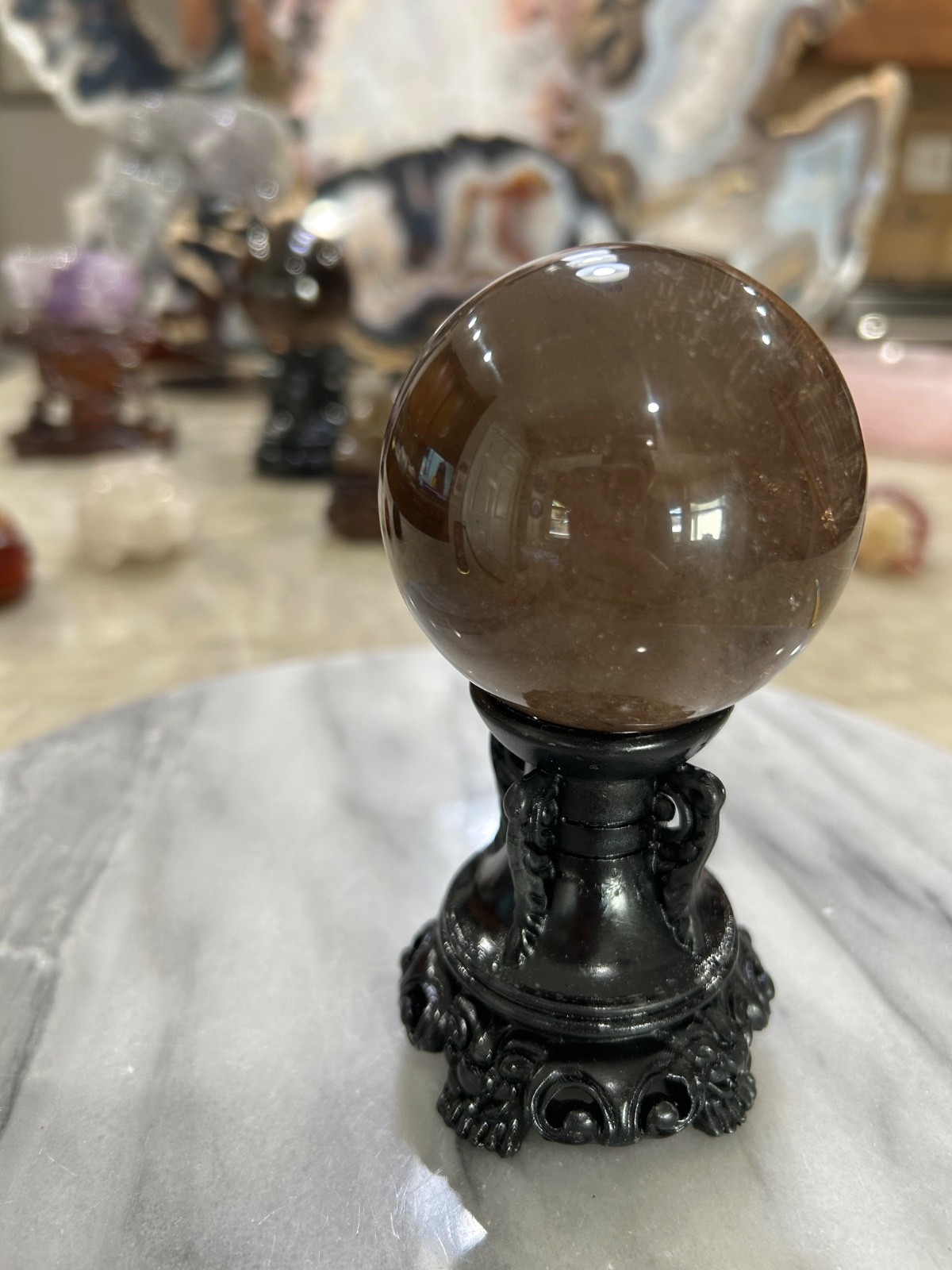 Smoky quartz rutile sphere on resin stand 2.47”