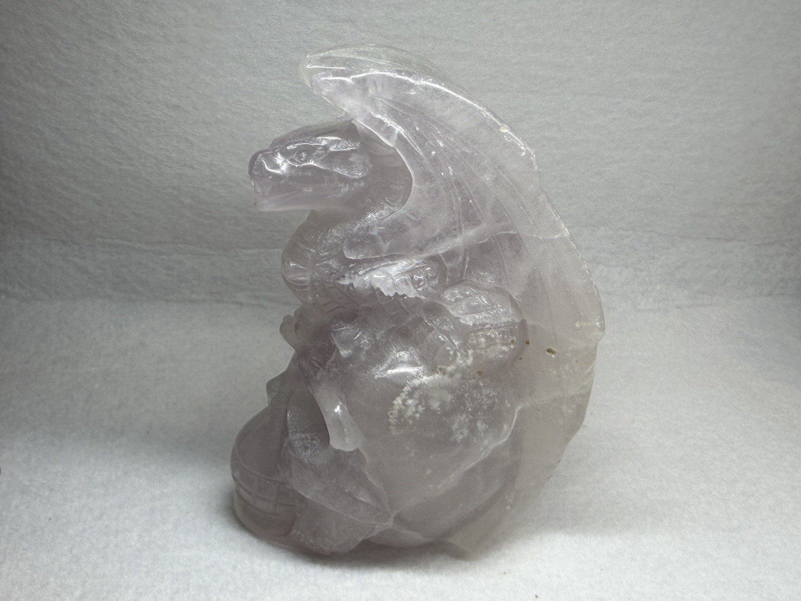 Hand-carved fluorite dragon perched on a human skull