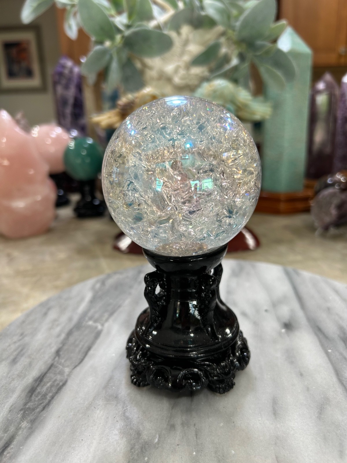 Aura coated quartz crackle sphere with black resin stand