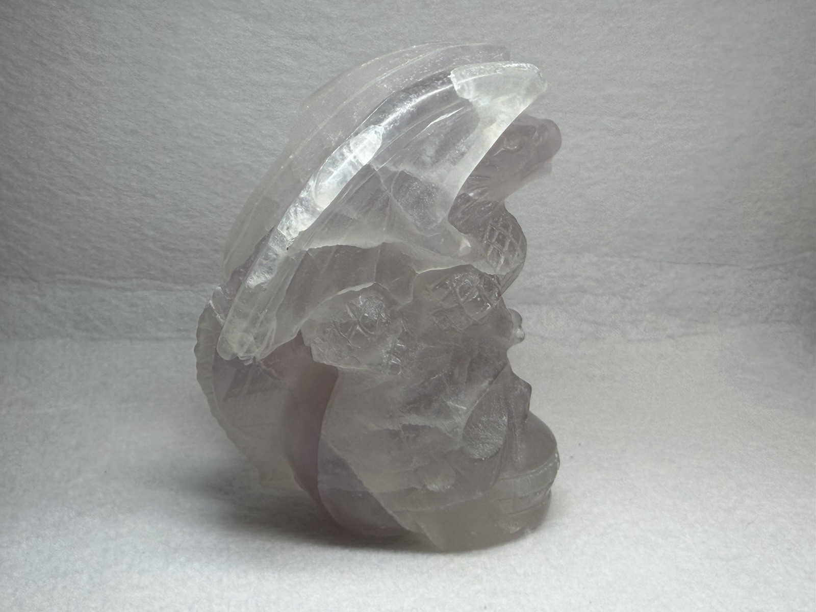 Hand-carved fluorite dragon perched on a human skull