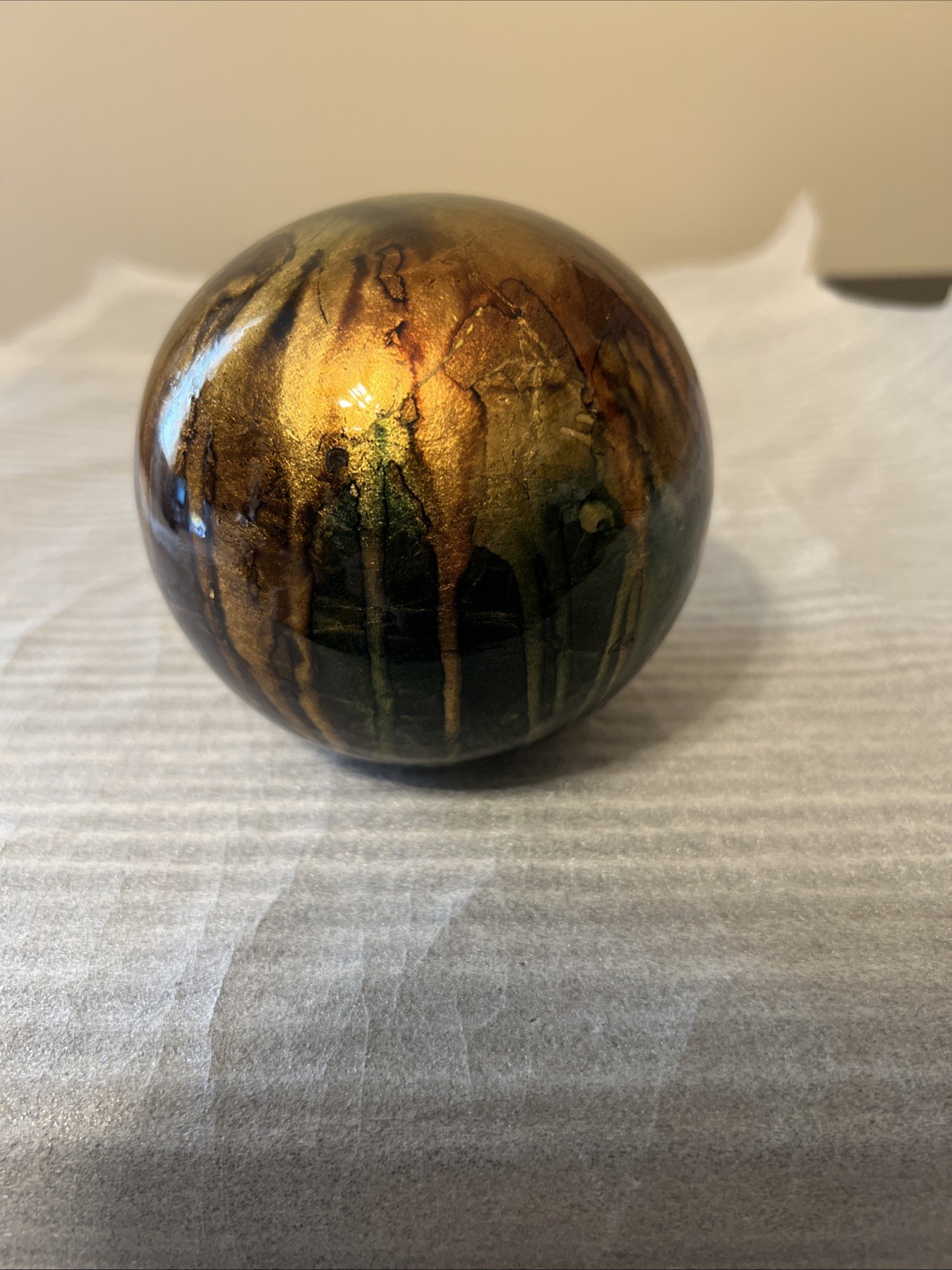 ceramic gazing ball paperweight with a colorful finish.