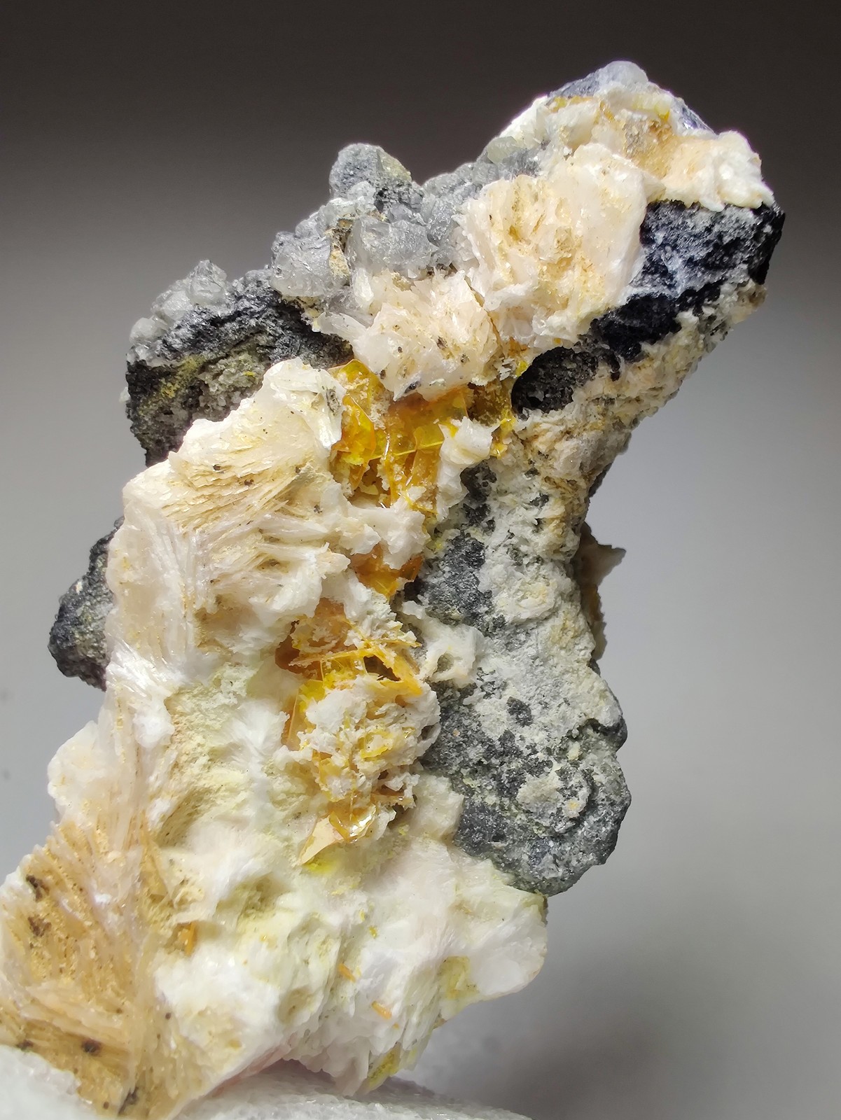 Wulfenite, Cerussite and Barite crystals, UV. Mibladen, Morocco. 6 cm.