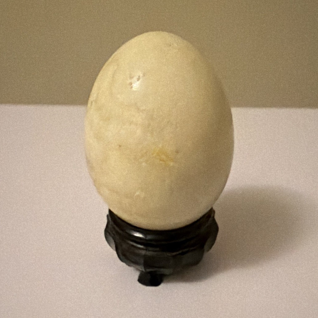 Egg-Shaped Polished Crystal Stone Figurine on Black Display Stand