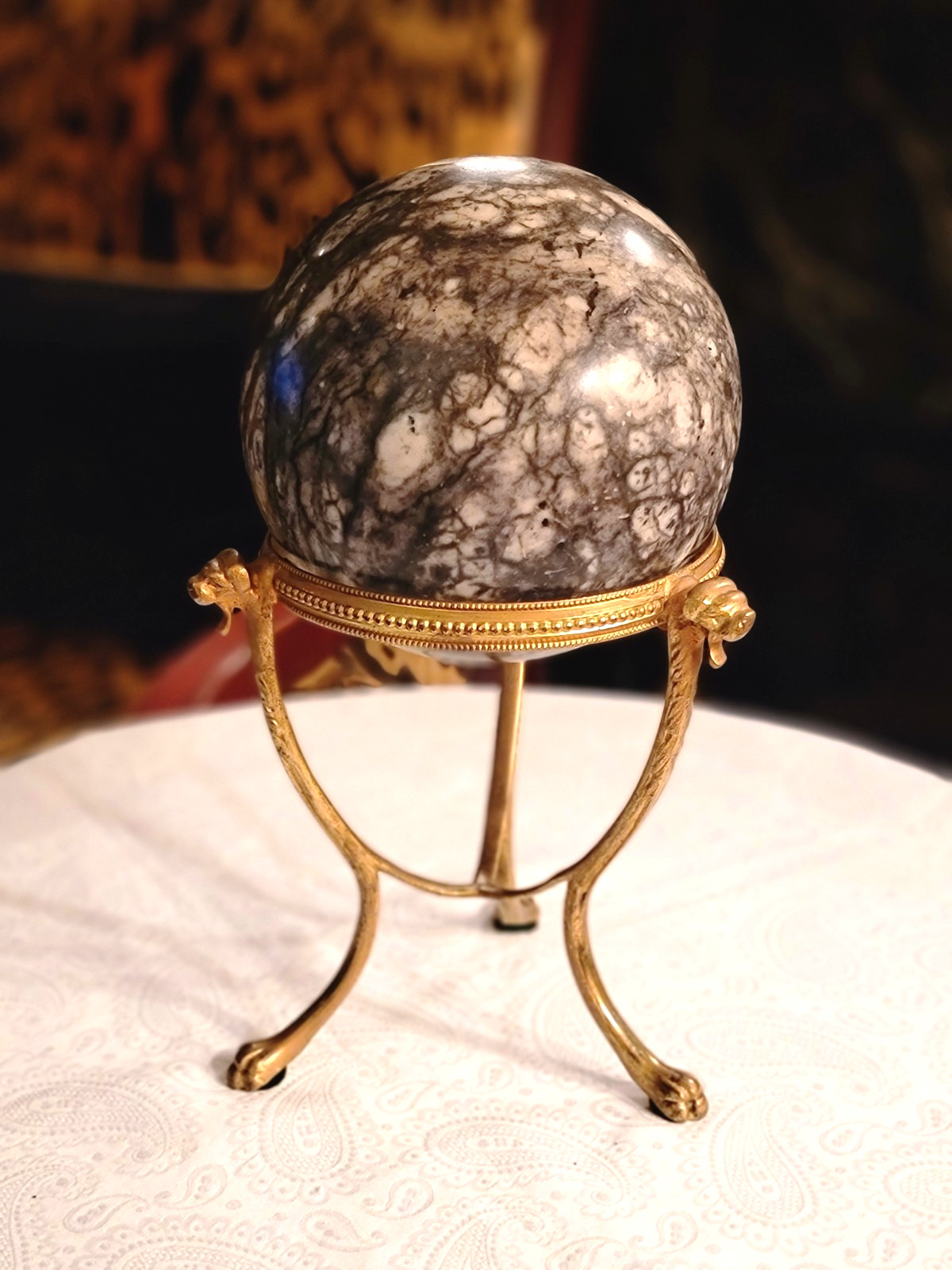 LARGE BLACK & GRAY MARBLE BALL WITH VINTAGE BRASS LION HEADS, 7.5”