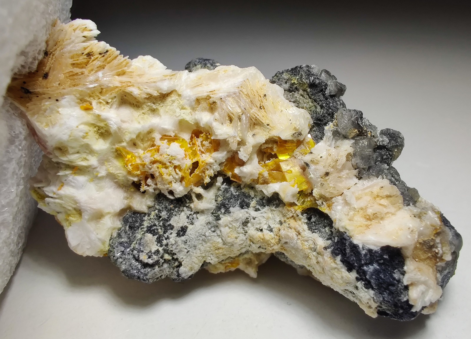 Wulfenite, Cerussite and Barite crystals, UV. Mibladen, Morocco. 6 cm.