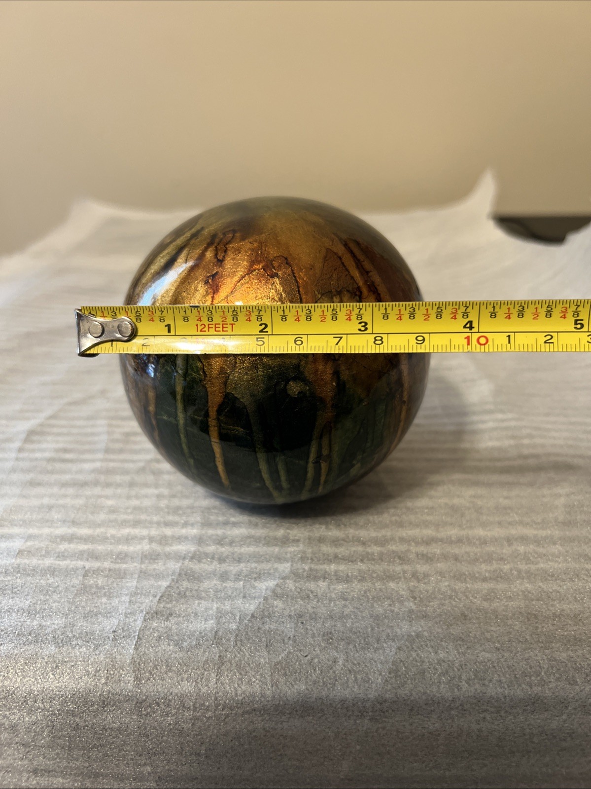 ceramic gazing ball paperweight with a colorful finish.