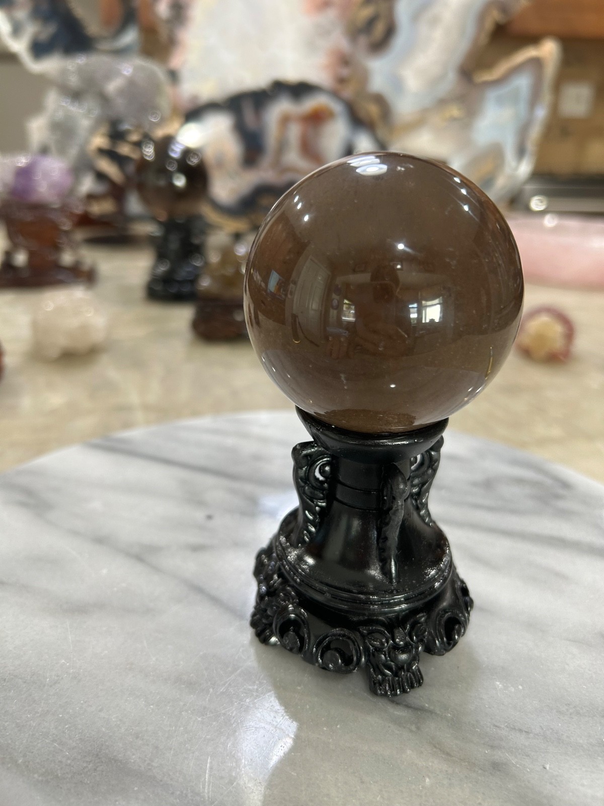Smoky quartz rutile sphere on resin stand 2.47”