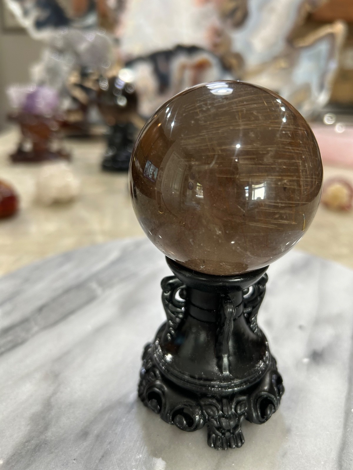 Smoky quartz rutile sphere on resin stand 2.47”