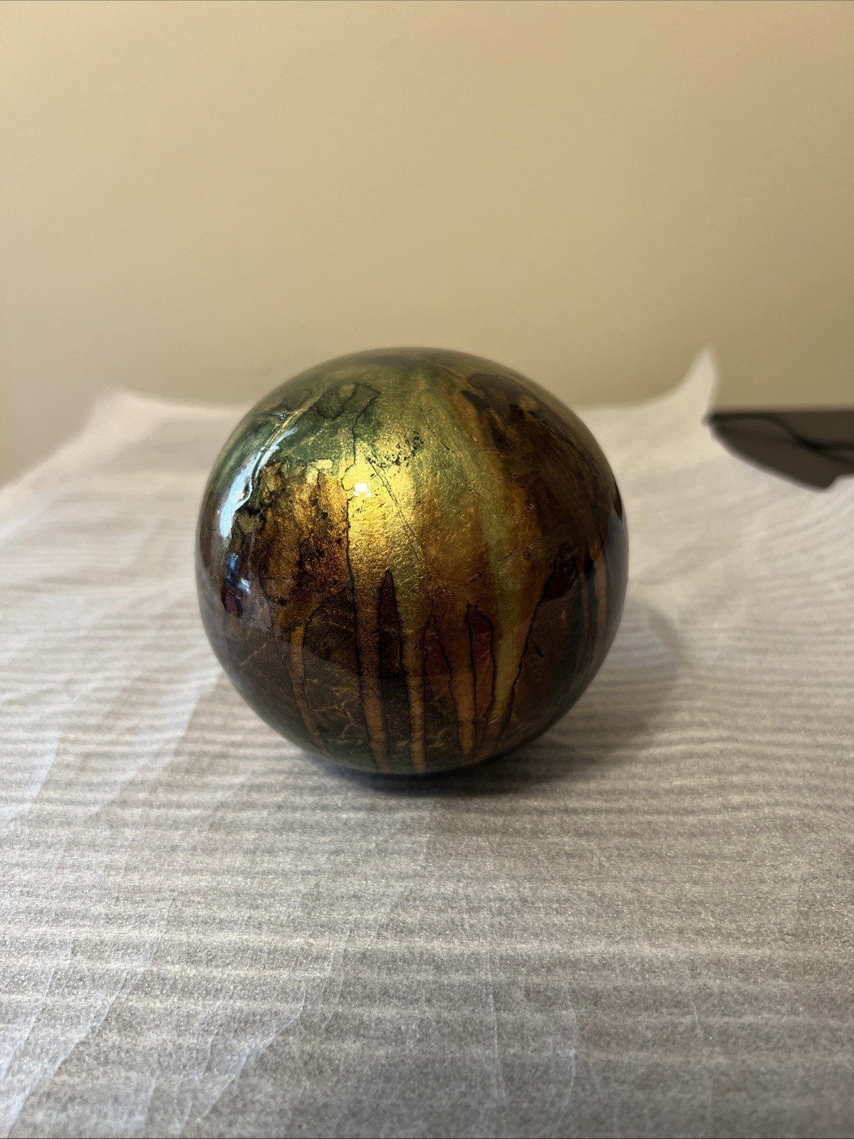 ceramic gazing ball paperweight with a colorful finish.